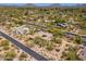 Expansive aerial view of desert-landscaped property featuring mature trees, pool, putting green, and beautiful mountains at 22469 N 79Th Pl, Scottsdale, AZ 85255