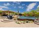 Spacious backyard showcasing a pool, fire pit, covered outdoor kitchen and immaculate landscaping at 22469 N 79Th Pl, Scottsdale, AZ 85255