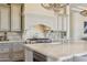 Gourmet kitchen featuring an island, professional gas range, custom hood, and pendant lighting at 22469 N 79Th Pl, Scottsdale, AZ 85255