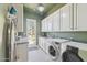 Bright laundry room with modern washer and dryer, white cabinets, and exterior access at 22469 N 79Th Pl, Scottsdale, AZ 85255