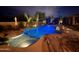 Well-lit backyard pool with stylish seating, unique rock features, and attractive decking at 22469 N 79Th Pl, Scottsdale, AZ 85255