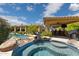 Inviting backyard oasis with a rock spa, a covered outdoor kitchen and lush landscaping at 22469 N 79Th Pl, Scottsdale, AZ 85255