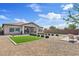 A landscaped backyard featuring a small lawn, decorative shrubs, and a paved patio area at 22825 E Mewes Rd, Queen Creek, AZ 85142