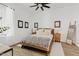 Bright bedroom with wooden bed frame, ceiling fan, and decorative ladder accents at 22825 E Mewes Rd, Queen Creek, AZ 85142