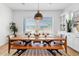 Bright dining room with bench seating at a wooden table under pendant lighting, overlooking the backyard at 22825 E Mewes Rd, Queen Creek, AZ 85142