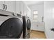 Convenient laundry room with modern washer and dryer units and ample cabinet space at 22825 E Mewes Rd, Queen Creek, AZ 85142