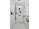 Bright white shower with marble-style tile, black hardware, and a built in bench and shelf at 22825 E Mewes Rd, Queen Creek, AZ 85142