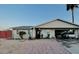 Charming home featuring a covered driveway, desert landscaping, and mature palm trees at 2459 E Baltimore St, Mesa, AZ 85213