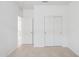 This carpeted bedroom contains a double door closet, a bedroom door and is painted white at 25473 W Graham Trl, Buckeye, AZ 85326