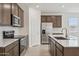 Modern kitchen features stainless appliances, tile backsplash, and a quartz countertop island at 25473 W Graham Trl, Buckeye, AZ 85326