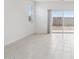 Bright living room with light tile flooring and sliding glass doors leading to the backyard at 25473 W Graham Trl, Buckeye, AZ 85326