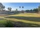 Scenic view of community park featuring a large grassy area, playground, and walking path at 2618 S 81St Ln, Phoenix, AZ 85043