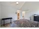 Bright bedroom with vaulted ceilings, tile floors, a bed with a floral comforter, and a glimpse into the connected bathroom at 2801 N Litchfield Rd # 37, Goodyear, AZ 85395