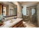 Stylish bathroom with a vessel sink, decorative mirror, adjacent to a glass shower featuring glass blocks at 29412 N 108Th Pl, Scottsdale, AZ 85262