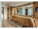 Elegant bathroom featuring wood cabinets, double sinks, and a large mirror reflecting a glass block shower at 29412 N 108Th Pl, Scottsdale, AZ 85262