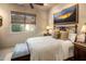 Cozy bedroom with a comfortable bed, side tables with lamps, and a picturesque desert scene painting at 29412 N 108Th Pl, Scottsdale, AZ 85262