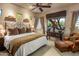 Inviting bedroom features a plush bed, decorative lamps, and a comfortable leather chair with ottoman at 29412 N 108Th Pl, Scottsdale, AZ 85262