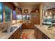 Kitchen with double sinks, granite countertops, wood cabinetry and view to the pool at 29412 N 108Th Pl, Scottsdale, AZ 85262