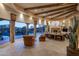 Elegant living room with beamed ceilings, tiled floors, fireplace, and picturesque backyard views at 29412 N 108Th Pl, Scottsdale, AZ 85262