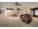 Expansive living room featuring comfortable leather seating, scenic views, a ceiling fan, and home theater setup at 29412 N 108Th Pl, Scottsdale, AZ 85262