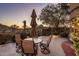 Cozy outdoor seating area with a patio table, umbrella, and views of the desert landscape at 29412 N 108Th Pl, Scottsdale, AZ 85262