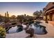 Backyard pool and patio area featuring natural stone accents and desert landscaping at 29412 N 108Th Pl, Scottsdale, AZ 85262