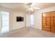 Bedroom with carpeted floor, television, ceiling fan, doorway, and wood storage shelves at 3109 N 81St St, Scottsdale, AZ 85251