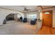 Spacious living room with a rock fireplace, ceiling fan, large window, and plush carpeting at 3109 N 81St St, Scottsdale, AZ 85251