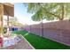 Fully fenced backyard featuring artificial grass, rock, and a concrete patio at 3706 E Yeager Dr, Gilbert, AZ 85295