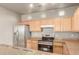 Well-equipped kitchen with stainless steel appliances, light wood cabinets, and granite countertops at 3706 E Yeager Dr, Gilbert, AZ 85295