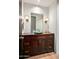 Powder room with dark wood vanity, rectangular mirror, and stylish light fixtures at 39810 N 105Th Way # 128, Scottsdale, AZ 85262