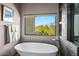 Bright bathroom featuring soaking tub with a view to the outside, sleek fixtures, and modern design elements at 39810 N 105Th Way # 128, Scottsdale, AZ 85262