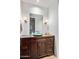 Bathroom vanity features dark wood cabinetry, unique glass sink, and elegant sconce lighting at 39810 N 105Th Way # 128, Scottsdale, AZ 85262