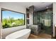 Bright bathroom featuring a standalone tub, walk-in shower and a large window with desert views at 39810 N 105Th Way # 128, Scottsdale, AZ 85262