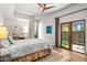 Bright bedroom with wooden floors, ceiling fan, and door to backyard patio at 39810 N 105Th Way # 128, Scottsdale, AZ 85262
