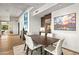 Dining room with a hardwood floor, modern table, and bright white chairs, accentuated by modern art at 39810 N 105Th Way # 128, Scottsdale, AZ 85262