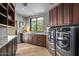 Well-lit laundry room with modern appliances, wooden cabinets, and ample counter space at 39810 N 105Th Way # 128, Scottsdale, AZ 85262