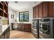 Laundry room features stainless steel washer and dryer units, counterspace, and wooden cabinets at 39810 N 105Th Way # 128, Scottsdale, AZ 85262