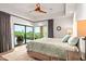 Serene main bedroom featuring a king bed, ceiling fan, and expansive windows with scenic desert views at 39810 N 105Th Way # 128, Scottsdale, AZ 85262