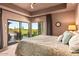 Bright and airy main bedroom with a large bed and views of the desert landscape at 39810 N 105Th Way # 128, Scottsdale, AZ 85262
