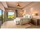 Bright, spacious main bedroom with a ceiling fan, plush carpet, and views of the desert landscape at 39810 N 105Th Way # 128, Scottsdale, AZ 85262