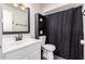 Bathroom offers white vanity and commode with a dark cabinet and shower curtain at 4349 W Morten Ave, Glendale, AZ 85301