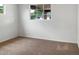 Bright bedroom with a window providing natural light and neutral carpet flooring at 4349 W Morten Ave, Glendale, AZ 85301