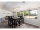 Bright dining room featuring dark wood table set and large windows overlooking the yard at 4349 W Morten Ave, Glendale, AZ 85301
