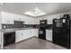 Well-lit kitchen with white cabinetry, black appliances, and modern backsplash at 4349 W Morten Ave, Glendale, AZ 85301