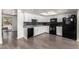 Bright kitchen with white cabinetry, black appliances, and modern backsplash at 4349 W Morten Ave, Glendale, AZ 85301