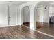 An open-concept living space with hardwood floors, white arches, and modern fixtures at 4349 W Morten Ave, Glendale, AZ 85301