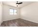 Inviting bedroom featuring hardwood floors, natural light, and a ceiling fan at 4542 N 86Th Dr, Phoenix, AZ 85037