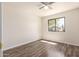 Bright bedroom featuring hardwood floors, ceiling fan, and a sunlit window at 4542 N 86Th Dr, Phoenix, AZ 85037