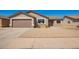 Tan single-story home features a two car garage and low maintenance gravel yard at 4542 N 86Th Dr, Phoenix, AZ 85037
